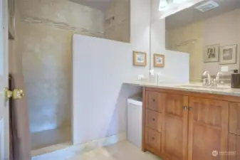 Bathroom off the primary bedroom with Travertine walk in shower and floor. New cabinet with slab granite counter.