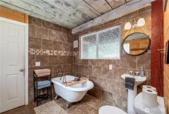 Charming Main Floor Second Bathroom    The second bathroom on the main floor includes a clawfoot tub, pedestal sink, and toilet—conveniently located between the foyer and laundry room.
