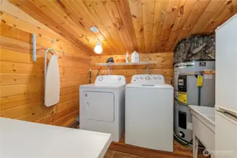 Practical Main Floor Utility Room    This utility room comes equipped with a washer, dryer, electric hot water tank, utility sink, and additional storage with a folding table for added convenience.