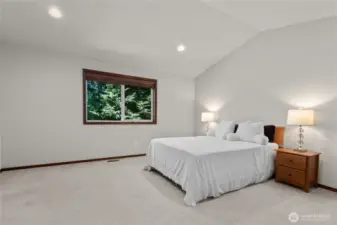Spacious primary suite has lush green view