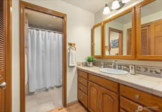 A complete guest split bathroom ensures convenient sharing! It boasts double vanities with extra-long counter space and a privacy  door that separates the bathtub and toilet.