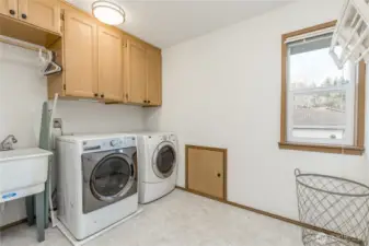 Convenient upstairs laundry with utility sink. Small door provides easy access to attic storage