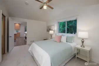 Primary suite with vaulted ceilings, ceiling fan, remodeled en-suite bath and walk in closet.