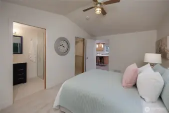Primary suite with vaulted ceilings, ceiling fan, remodeled en-suite bath and walk in closet.
