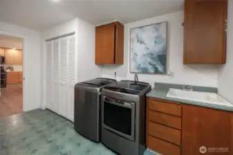 Large laundry room with sink and storage.