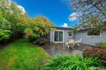 Beautifully landscaped backyard with patio and storage shed.