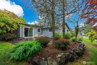 Beautifully landscaped backyard with patio and storage shed.