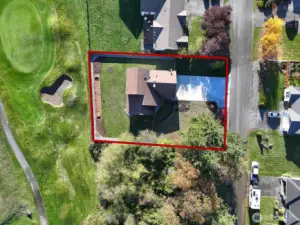 Drone shot of the home, approximate property lines and location near lovely trees and the golf course.