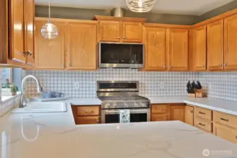 Kitchen looking in from counter where stools are tucked in.