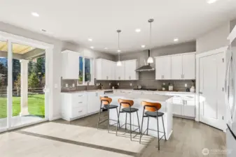 Large chef kitchen with hard-surface countertops. Photo rendering is representational. Actual home is under construction and finishes, elevation, and paint colors may vary. See site agent for details.