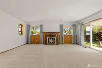 A cozy fireplace and multiple windows.