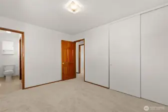 Looking from the back of the primary bedroom to the hallway and closets.