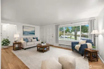 Virtually staged angle of the living room showcasing the large picture window and spacious layout.