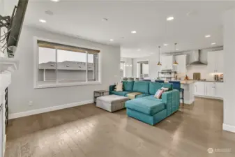 The great room with built-in speakers, a gas fireplace, and access to the deck.