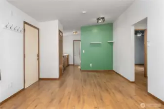 This central hallway ties the home together—connecting bedrooms, bathroom, and kitchen. The accent wall adds character and potential for a creative workspace, play area, or dining nook.