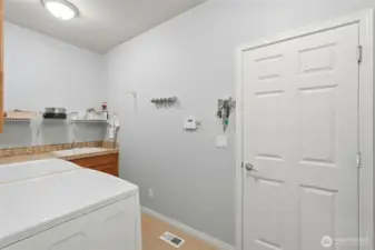 Utility room designed for function with sink and direct garage access.