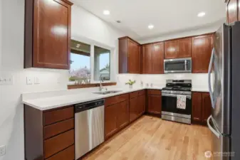 Spacious cooks kitchen with upgrades and modern conveniences - solid surface quartz counters, stainless appliances and undercabinet lighting.