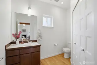 Main floor powder room with access to oversized laundry area, featuring upgraded front load washer and dryer.