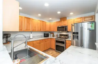 New stainless appliances, farm-style sink, quartz counters