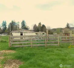 small wooden corral for critters behind shop