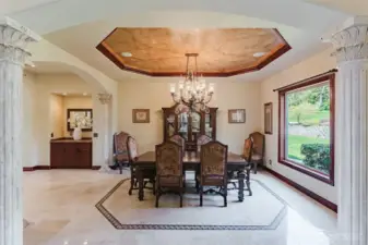 The formal dining area has recessed lighting with beautiful faux painted ceilings, an impressive crystal chandelier, and is surrounded by 8 solid marble columns with Temple of the Winds capitals throughout the lower living area. The butler pantry and bar are located near the formal dining, offering a perfect layout for entertaining.