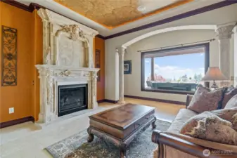 The living room has a 10ft. high sculptured marble fireplace and a lovely view of the pool and pool deck. This room includes stunning lighted soffit faux painted ceilings.