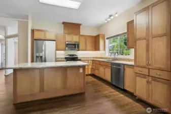 Updated kitchen with quartz, center island eating bar and stainless appliance package, opens to family room, eating area and dining room