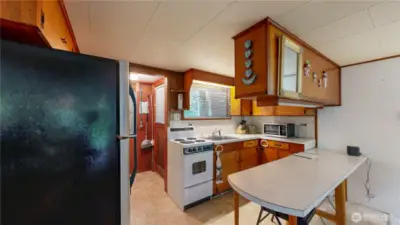 Charming kitchen with classic wood cabinetry, counters, and a cozy breakfast bar.