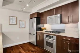 The kitchen is highlighted with stainless steel appliances and a gas cooktop.