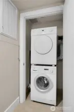 The laundry closet has a stack Bosch washer and dryer.