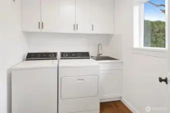 Conveniently situated between the garage and kitchen, the laundry room features a handy sink and extra storage, making chores feel a little less like work.