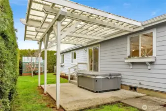 The backyard features a covered pergola, offering shelter for outdoor dining, relaxing, or enjoying the fresh air rain or shine.