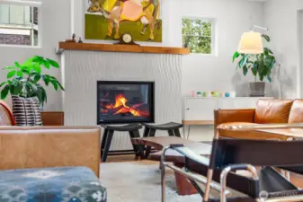 The sculptural wave-tile fireplace with wood mantel is the heart of the living room — a striking focal point that's as functional as it is beautiful.