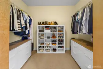 The walk-in closet offers dual hanging rods, drawers with wood-topped surfaces, and a dedicated shoe tower — storage that keeps up with a full wardrobe.