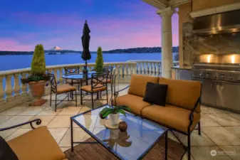 Outdoor Patio on main level features modern living space for dining and entertainment with built-in grill and limestone flooring.
