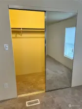 Large mirrored walk in closet in primary