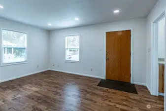 Living room with Oak veneer front door & LVP plank flooring.