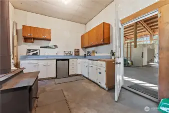 Main floor has a big shop space with lots of counters and cupboards. Wood stove for heat, its own propane tank and big compressor. Plus ventilation.