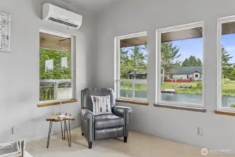 Living room corner offers a picturesque view of the stunning canal, complemented by a sleek Mitsubishi mini-split system for efficient heating and cooling.