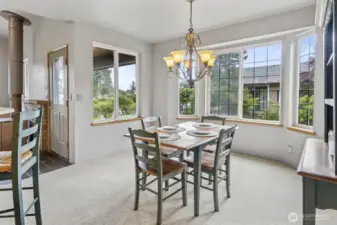 Dining room filled with natural light from expansive picture windows.