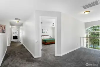 View of the hall upstairs with the door to the right is a bedroom and then a room at the end of the hall. To the right overlooks the entry and out to the front yard