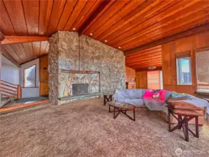 Soaring ceilings and statement rock fireplace in living room provides timeless elegance