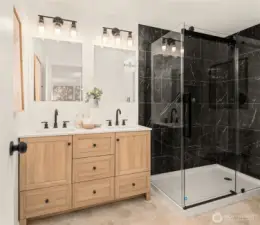 Updated primary bathroom with tiled shower and double vanity.