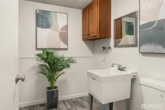 Half bath with washer & dryer hookups and utility sink.