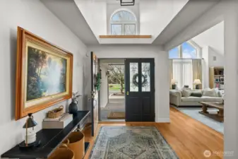 Classic wood door opens to the bright entryway with new chandelier and refinished oak hardwood floors.