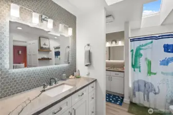 Updated Jack & Jill full bath between bedrooms: New vanities, light fixtures, mirrors, floor tile, shower tile and hardware.