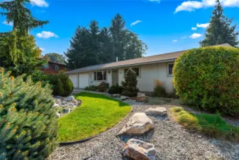 Beautifully landscaped front yard with mature plants and a drip system already in place.