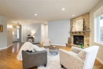 Another view of the living room area, with gas fireplace at right and entry on left.  Door at center-back is the under-stair storage area.
