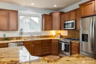 Slab granite counters, stainless appliances, including built-in microwave.