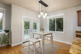 The dining area with hardwood floors and French doors to a composite deck and private back yard.